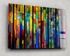 a multicolored stained glass piece hanging on the wall