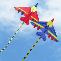 two kites flying in the sky on a sunny day with blue and white clouds