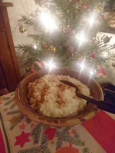 a bowl filled with food sitting on top of a table next to a christmas tree