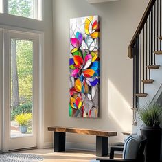 an abstract painting hangs on the wall next to a wooden bench in a living room