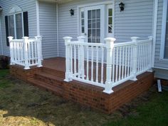 a porch with white railings and brick steps