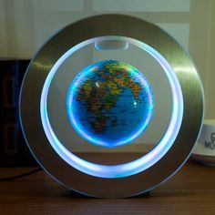 an illuminated globe sits on top of a wooden table