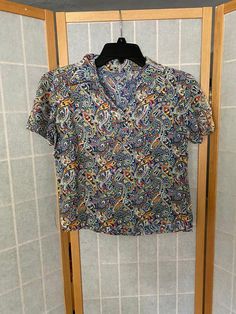 Gorgeous 1940’s rainbow short sleeve blouse. Pulls over the head, has a single snap at the collar. One line of sun fading on the left shoulder. Has a few pin holes on the back and a hole in the front. See all photosBust: 36”Waist: 36”Shoulder to hem: 19.5” Fitted Short Sleeve Shirt With Paisley Print, Fitted Multicolor Shirt With Camp Collar, Multicolor Cotton Top With Collared Neckline, Retro Patterned Short Sleeve Tops, Multicolor Floral Print Top With Collared Neckline, Multicolor Collared Top With Retro Print, Retro Multicolor Print Collared Top, Vintage Patterned Top With Camp Collar, Vintage Multicolor Short Sleeve Tops