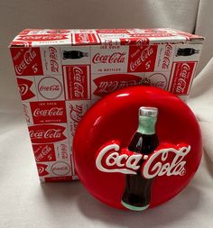 a coca - cola bottle sitting in front of a box