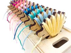 several skeins of colored yarn sitting on top of a wooden box with holes in it