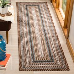 a rug is on the floor next to a blue vase