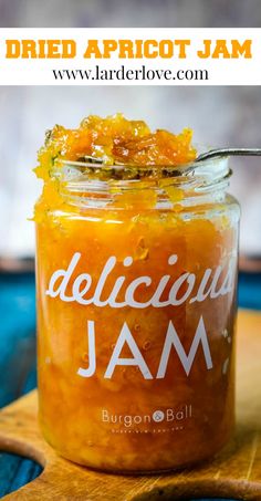 a jar filled with jam sitting on top of a wooden cutting board