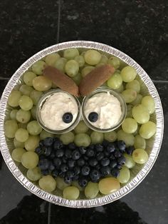 a plate with grapes, grapes and yogurt in the shape of a face