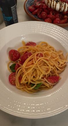 a white plate topped with spaghetti and tomatoes