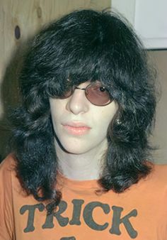 a man with long black hair wearing sunglasses and a t - shirt that says trick or treat