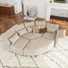 a living room with a large round couch in the center and a fire place behind it