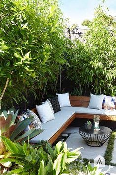 an outdoor seating area is surrounded by greenery