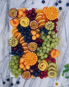 an arrangement of fruit is displayed on a marble surface