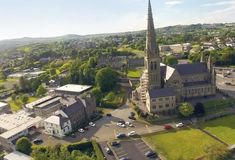 an aerial view of a large church in the middle of a town with lots of trees