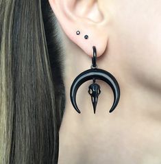 SOLD AS 1 PAIR Eye catching large Moon and Raven skull hoop earrings are made of 316L Stainless steel . 316L Stainless steel is considered hypoallergenic, and won't tarnish or rust. Moon and Raven skull charm is detachable from the hoop. Size:1 3/4 long (from edge to edge),1 1/4 wide Hoop inner diameter: 11mm Post :0.7mm / 22G  (regular post) Ships in a gift box Black Hoops Earrings, Raven Skull, Face Piercings, Skull Earrings, Black Earrings, Moon Earrings, Cartilage Earrings, Jewelry Inspo, Jewelry Earrings Hoops