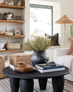 a living room filled with lots of furniture and books on top of a coffee table