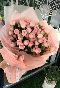 a person holding a bouquet of pink roses