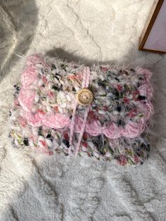 a pink and white purse sitting on top of a bed