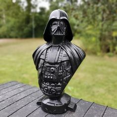 a star wars figurine sitting on top of a wooden table in the grass