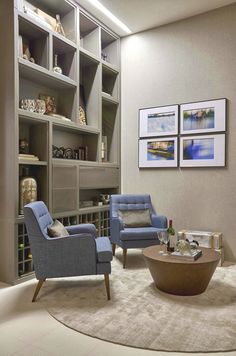 a living room with two chairs and a coffee table in front of a bookshelf