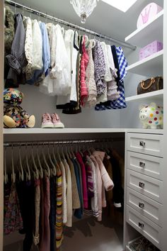 an organized closet with clothes and shoes hanging on the rails, drawers, and shelves