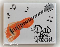 an orange ukulele with music notes and the words dad rock painted on it