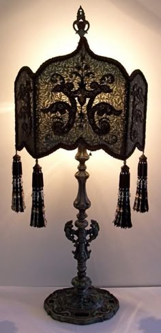 an ornate table lamp with tassels on it