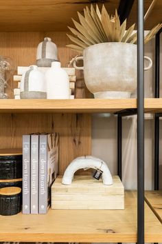 a book shelf with books, vases and other items on it's shelves