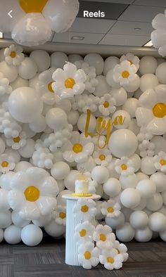 balloons and flowers are arranged on the wall in an office lobby for a birthday party