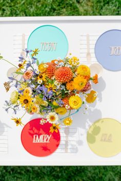 a bouquet of flowers sitting on top of a white board with different colored circles around it