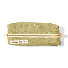 a green and white cosmetic bag with the word slow north on it's side