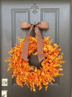 an orange wreath is hanging on the front door