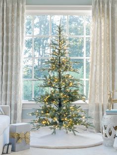 a small christmas tree sitting in front of a window