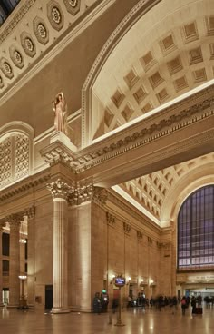 the inside of a train station with people walking around