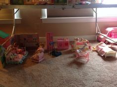 there are many toys on the floor in this room and one has a doll house