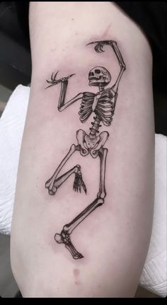 a skeleton tattoo on the leg of a woman