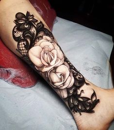 a woman's leg with black lace and roses on it