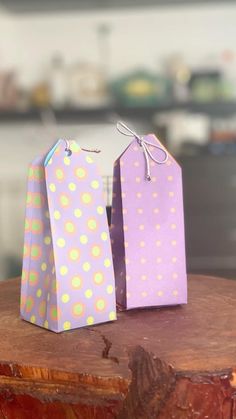 two purple and yellow bags sitting on top of a wooden table next to each other