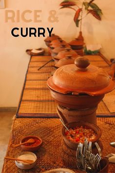 the cover of rice and curry is shown on a table with bowls, spoons and utensils