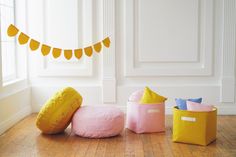 three storage bins sitting on the floor in front of a wall with bunting flags