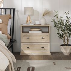 a bedroom scene with focus on the dresser and bed side table in the foreground