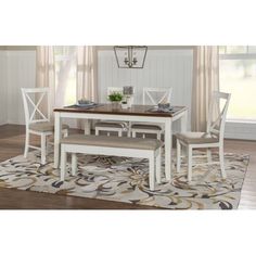 a dining room table and chairs with a rug on the floor