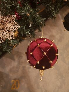 a red ornament hanging from the ceiling next to a christmas tree with decorations