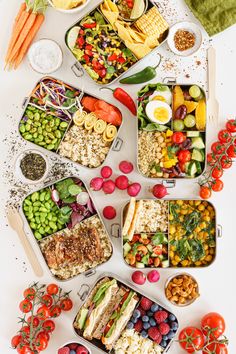 a table topped with lots of trays filled with different types of foods and veggies