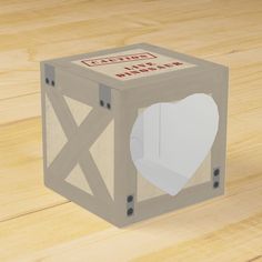 a cardboard box with a heart cut out of it sitting on top of a wooden floor