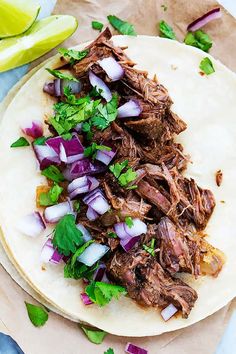 a tortilla with meat, onions and cilantro