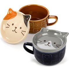 three ceramic mugs with cat faces on them