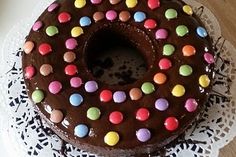 there is a chocolate cake with colorful candies on the frosting and icing