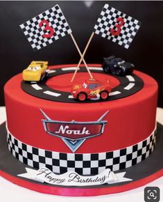 a birthday cake decorated with cars and flags