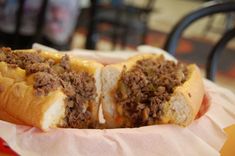 a close up of a sandwich with meat and cheese on it sitting on a table